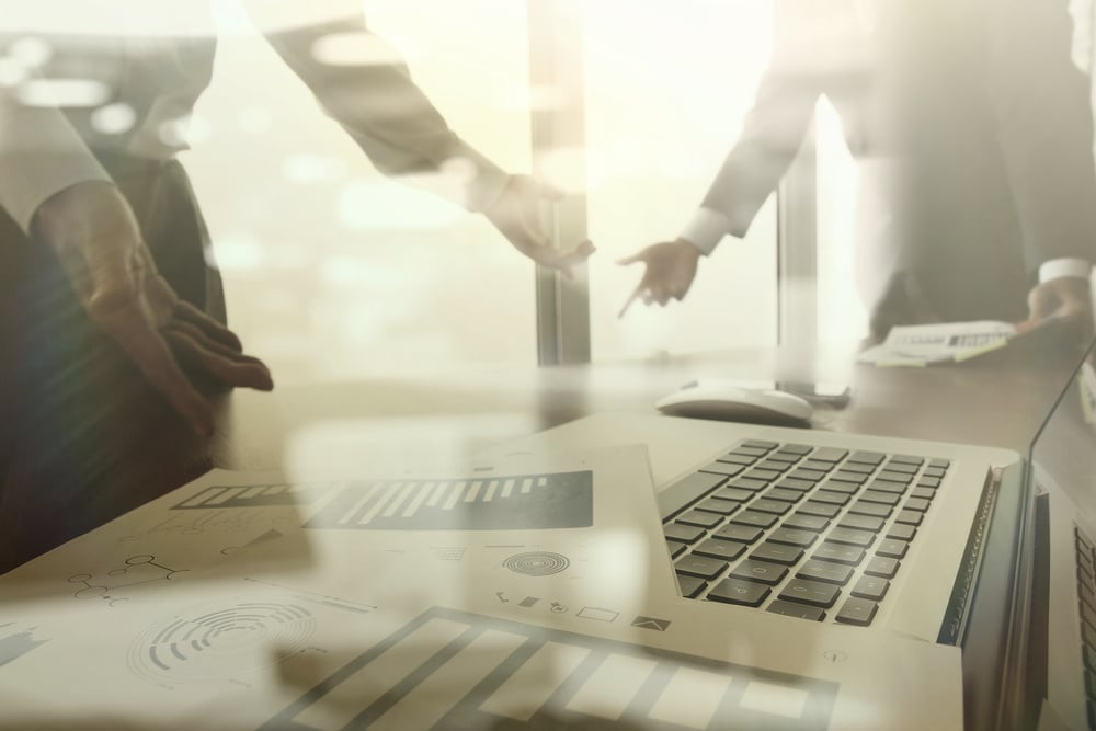 business documents on office table with smart phone and digital tablet and graph business diagram and man working in the background